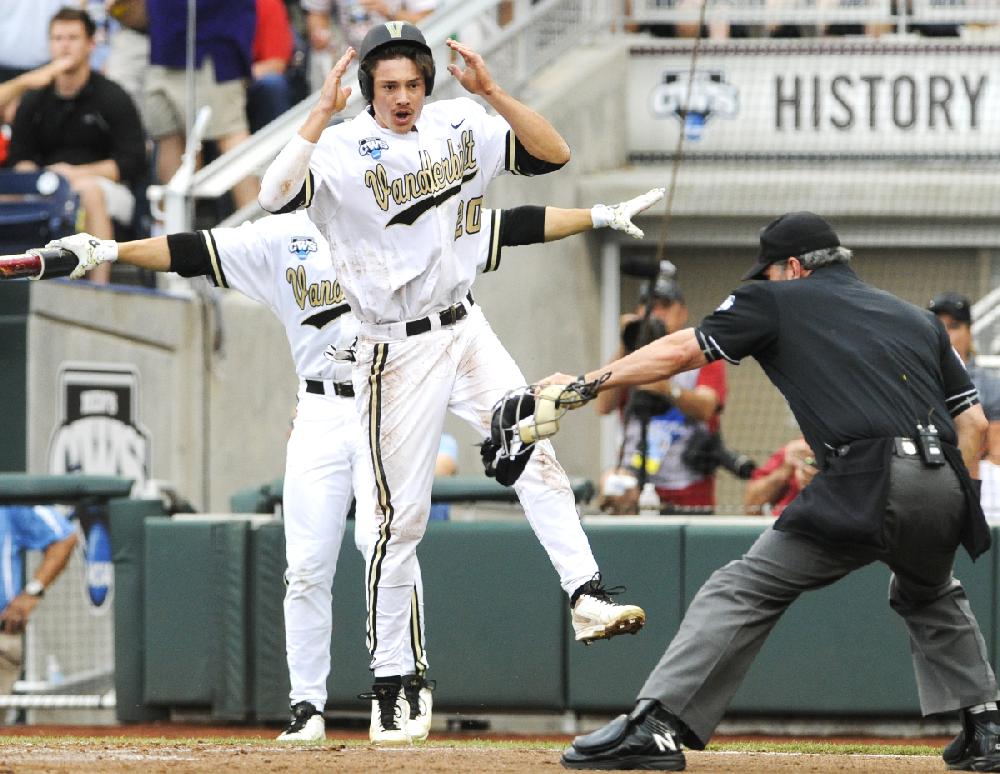 Vanderbilt's Bryan Reynolds (20) awaits the umpire's call after he scored against UC Irvine on a bunt by teammate Xavier Turner in the first inning of an NCAA baseball College World Series game in Omaha, Neb., Monday, June 16, 2014. (AP Photo/Eric Francis)