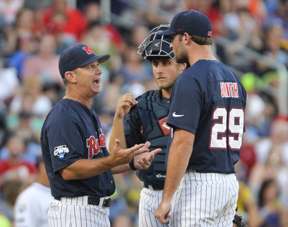 Mississippi coach Mike Bianco, left, talks to pitcher Sam Smith (29) and catcher Austin Knight, center, in the fourth inning of an NCAA baseball College World Series elimination game against TCU in Omaha, Neb., Thursday, June 19, 2014. (AP Photo/Ted Kirk)