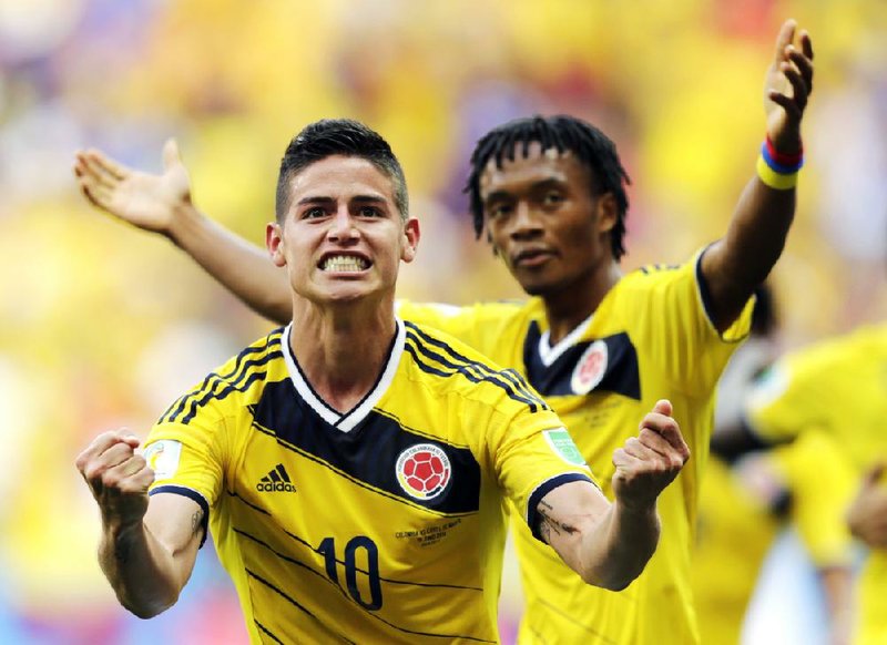 Colombia’s James Rodriguez (10) celebrates with teammate Colombia’s Juan Cuadrado after scoring his side’s first goal during the Group C World Cup soccer match between Colombia and Ivory Coast at the Estadio Nacional in Brasilia, Brazil, on Thursday. 