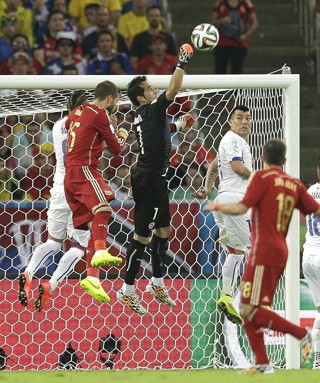 Chile’s goalkeeper Claudio Bravo (center) clears a shot from the mouth of the goal during a 2-0 victory over Spain in a Group B match Wednesday in Rio de Janeiro.