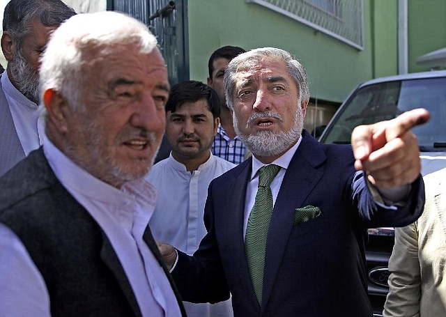 Afghan presidential candidate Abdullah Abdullah (right) leaves after a news conference Wednesday in Kabul during which he said his vote monitors had observed ballot-box stuffing and other irregularities at Saturday’s polling.