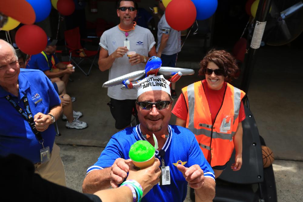 Arkansas Democrat-Gazette/RICK MCFARLAND --06/19/14--     Pete Currey, ramp agent with Southwest Airlines, gets a sno-cone from Dalette Vickers, in her Kona Ice truck, at the Bill & Hillary Clinton National Airport in Little Rock Thursday. The cool treats were a thank you from the airline to there ground operation employees who work in the extreme heat unloading and loading luggage on planes.