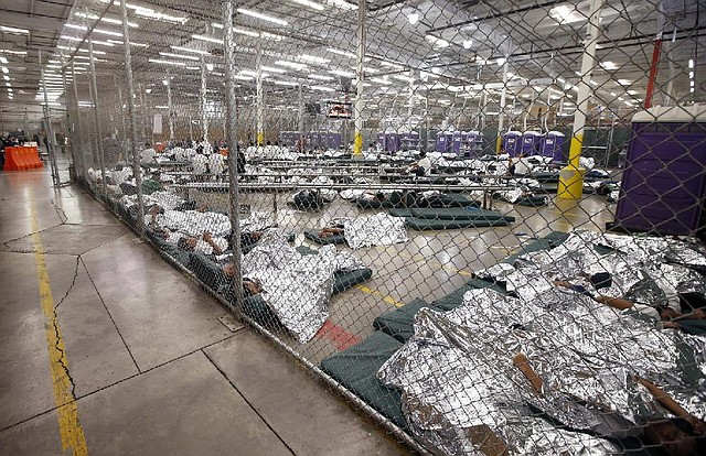 Detainees sleep or watch television Wednesday in a U.S. customs holding cell in Nogales, Ariz., where hundreds of children, mostly from Central America, are being held and processed.