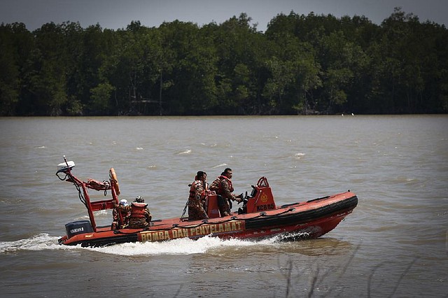 Malaysian rescuers search Wednesday for passengers of a sunken boat near Banting.