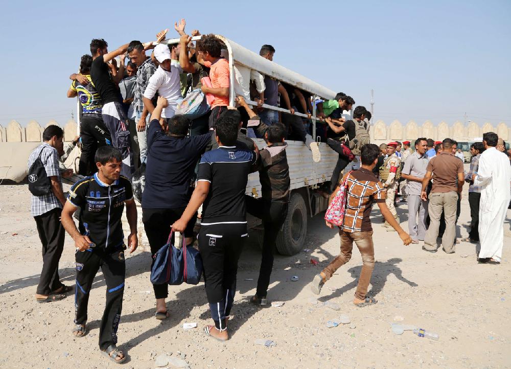 Iraqi men crowd a truck to join the Iraqi army at the main recruiting center in Baghdad, Iraq, Thursday, June 19, 2014, after authorities urged Iraqis to help battle insurgents. he campaign by the al-Qaida-inspired Islamic State militants has raised the specter of the sectarian warfare that nearly tore the country apart in 2006 and 2007, with the popular mobilization to fight the insurgents taking an increasingly sectarian slant, particularly after Iraq's top Shiite cleric made a call to arms on Friday. (AP Photo/Karim Kadim)