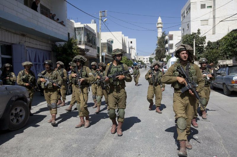 Israeli soldiers search Wednesday for three Israeli teenagers in the village of Taffouh near the West Bank city of Hebron. The three are feared kidnapped by Palestinian militants and have been missing about a week.