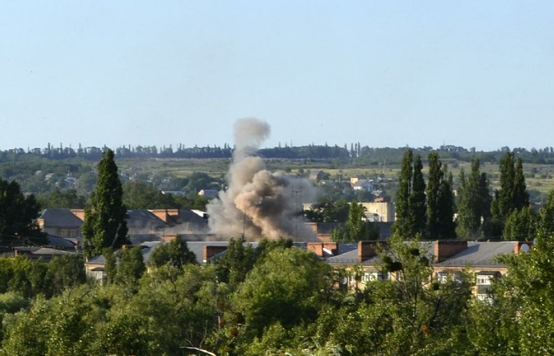 Smoke rises from an explosion near a children's hospital following shelling from Ukrainian government forces in Slovyansk, Ukraine, Thursday, June 19, 2014. Heavy fighting raged near Krasnyi Liman, just east of the rebel stronghold of Slovyansk, a city in the Donetsk region that has been the epicenter of violence during the past two months. (AP Photo/Andrei Petrov)