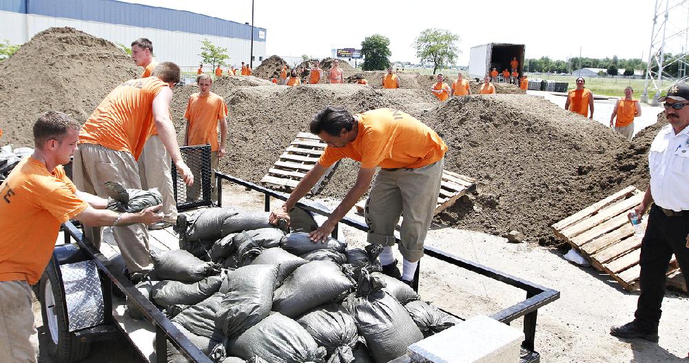 Inmates from Yankton load sand bags into a truck bed at the former weigh station in North Sioux City, S.D., on Thursday, June 19, 2014. People along the river were working to battle record flooding. (AP Photo/Sioux City Journal, Dawn J. Sagert)