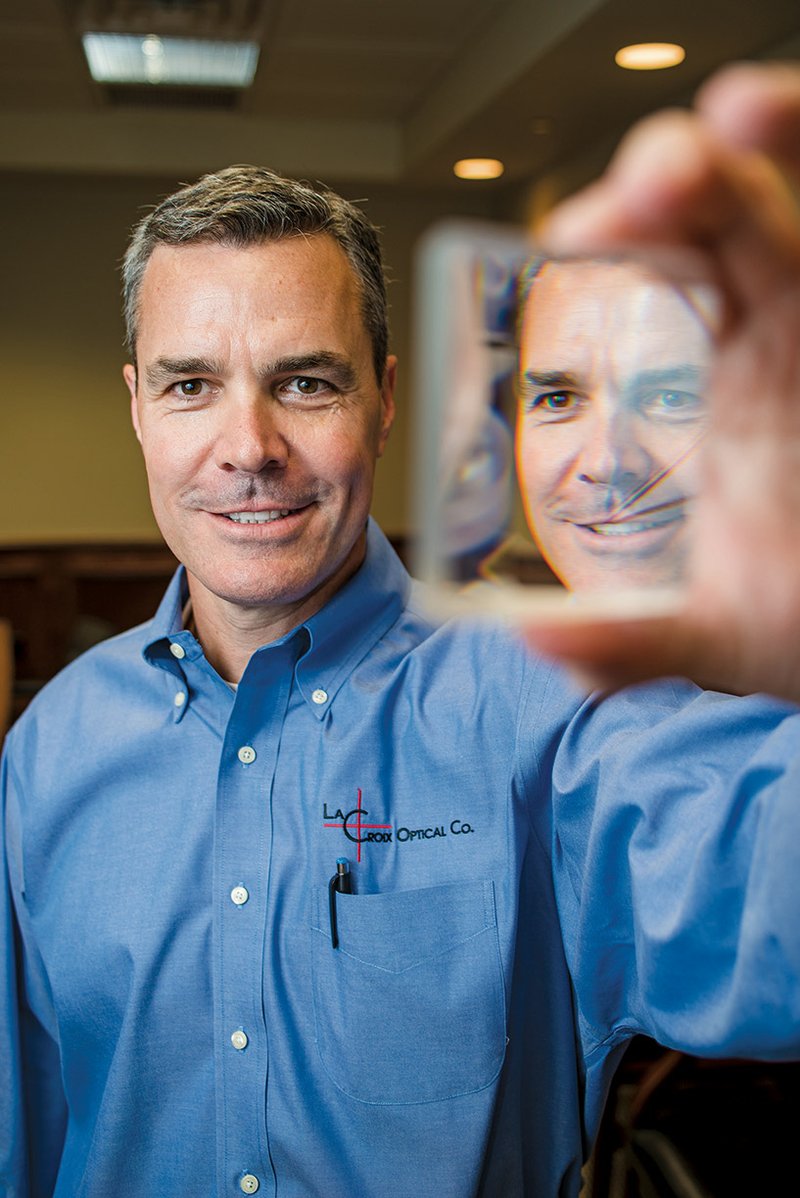 Kirk Warden is co-founder of the Arkansas Photonics Industry Alliance and executive vice president of LaCroix Optical Co. in Batesville, which manufactures custom lenses for a variety of defense, medical and other uses. He holds a large prism made by the company.