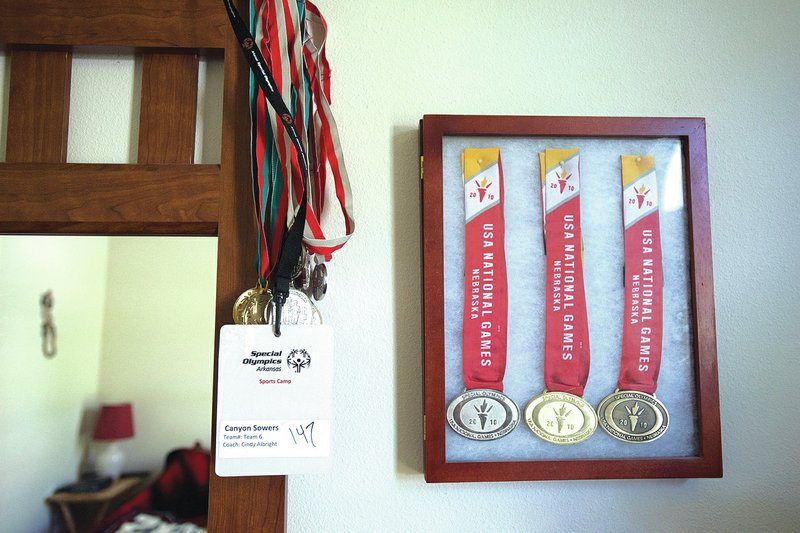 STAFF PHOTO SAMANTHA BAKER &#8226; @NWASAMANTHA Medals from the 2010 USA Games are kept in a glass case and hung on the wall in Sowers&#8217; bedroom. &#8220;Canyon is probably the best swimmer in the state,&#8221; said David Thrift, Sower&#8217;s sprint triathlon partner.