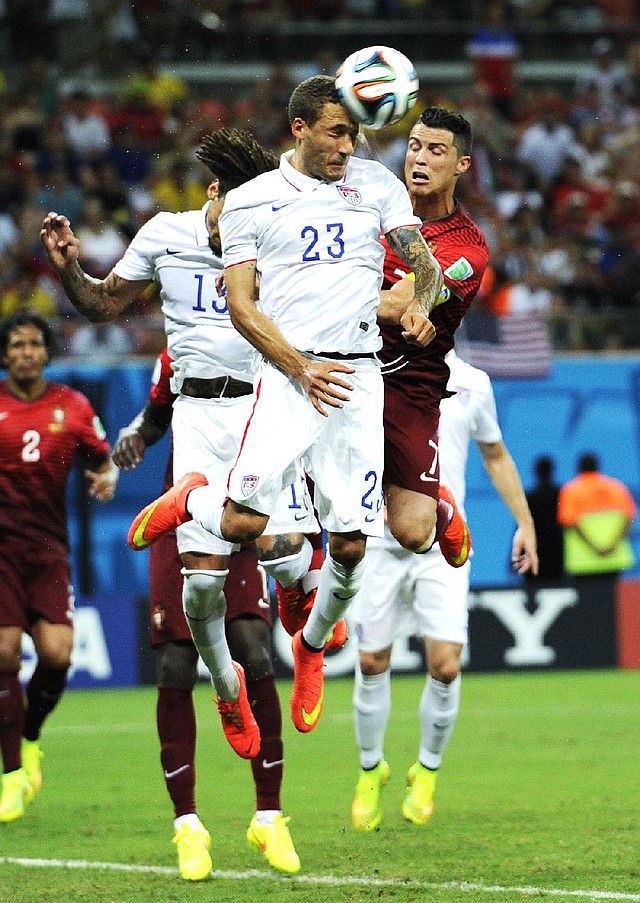 United States' Fabian Johnson (23) heads the ball away from Portugal's Cristiano Ronaldo, right, during the group G World Cup soccer match between the USA and Portugal at the Arena da Amazonia in Manaus, Brazil, Sunday, June 22, 2014. (AP Photo/Paulo Duarte)