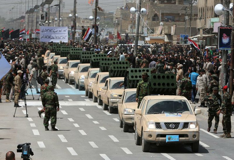 A line of rocket-launcher-equipped trucks moves by as Shiite volunteers parade through the Sadr City area of Baghdad on Saturday to show their readiness to take on Sunni insurgents.