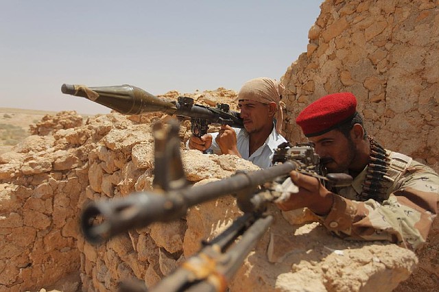 Iraqi Shiite tribal fighters deploy outside the Shiite holy city of Najaf, 100 miles (160 kilometers) south of Baghdad, Iraq, Sunday, June 22, 2014. Sunni militants on Sunday captured two border crossings, one along the frontier with Jordan and the other with Syria, security and military officials said, as they pressed on with their offensive in one of Iraq's most restive regions. (AP Photo/Jaber al-Helo)