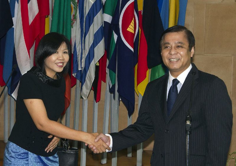 Cambodian Ambassador to Thailand Eat Sophea, left, shakes hands with Thai Foreign Ministry's Permanent Secretary Sihasak Phuangketkeow after meeting at Foreign Ministry in Bangkok, Thailand Tuesday, June 17, 2014. The number of Cambodians who have returned home from Thailand this month after a threatened crackdown on foreigners working illegally has topped 160,000, a Cambodian official said. (AP Photo/Sakchai Lalit)