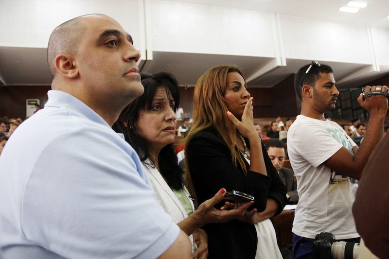 Adel Fahmy, brother of Mohamed Fahmy, left; Wafa Bassiouni, mother of Mohamed Fahmy, second left; and his fiancee, third left, watch proceeding during the sentencing hearing for journalists working for Al-Jazeera in a courtroom in Cairo, Egypt, on Monday, June 23, 2014. An Egyptian court on Monday convicted three journalists from Al-Jazeera English and sentenced them to seven years in prison each on terrorism-related charges.