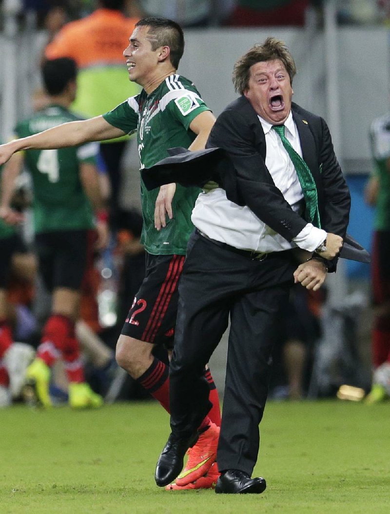 Mexico's head coach Miguel Herrera celebrates after Mexico's Andres Guardado  scored his side's second goal during the group A World Cup soccer match between Croatia and Mexico at the Arena Pernambuco in Recife, Brazil, Monday, June 23, 2014.  (AP Photo/Petr David Josek)