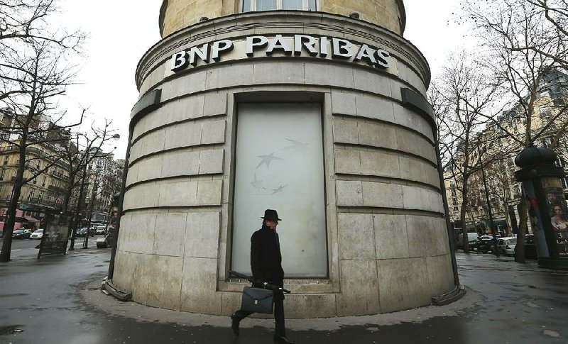 FILE - In this Feb. 5, 2013 file photo, a man walks past the French bank BNP Paribas headquarters in Paris. French economy minister Arnaud Montebourg on Monday, June 23, 2014 is urging U.S. authorities to be "fair and proportionate" when deciding on a potential multibillion-dollar fine against France's largest bank over its activities in countries Iran, Sudan and Cuba. (AP Photo/Jacques Brinon, File)