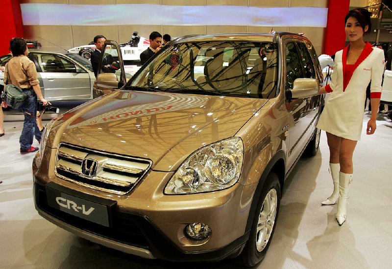 FILE - In this April 21, 2005 file photo, a model poses by a Honda's CR-V at Auto Shanghai 2005 exhibition in Shanghai, China. Honda, Mazda and Nissan are recalling millions of vehicles globally for defective airbags manufactured by supplier Takata Corp. that could possibly explode. No accidents have been reported related to recalls Monday, June 23, 2014. Honda Motor Co. recalled 2.03 million vehicles for the airbag problem, including 1.02 million in North America and nearly 669,000 in Japan. The models recalled at Honda include the Fit, Element and CR-V, manufactured between 2000 and 2005. (AP Photo/Eugene Hoshiko, File)