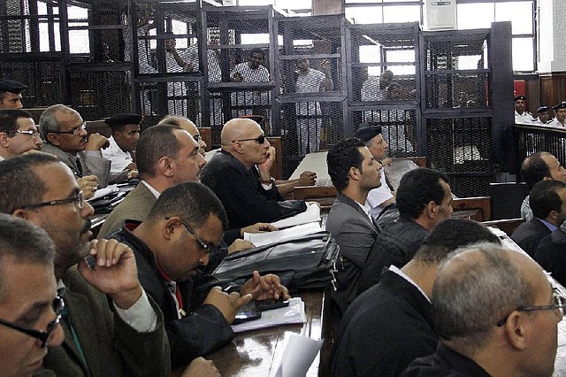 Lawyers attend the sentencing hearing for journalists working for Al-Jazeera in a courtroom in Cairo, Egypt, Monday, June 23, 2014. An Egyptian court on Monday convicted three journalists from Al-Jazeera English and sentenced them to seven years in prison each on terrorism-related charges, bringing widespread criticism that the verdict was a blow to freedom of expression. The three, Australian Peter Greste, Canadian-Egyptian Mohamed Fahmy and Egyptian Baher Mohammed, have been detained since December charged with supporting the Muslim Brotherhood, which has been declared a terrorist organization, and of fabricating footage to undermine Egypt's national security and make it appear the country was facing civil war.  (AP Photo/Heba Elkholy Newspaper)    EGYPT OUT