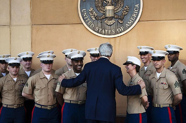 U.S. Secretary of State John Kerry greets U.S. Marines as he arrives at the U.S. Embassy in Baghdad, Iraq, Monday, June 23, 2014. Kerry said the fate of Iraq may be decided over the next week and is largely dependent on whether its leaders meet a deadline for starting to build a new government. (AP Photo/Brendan Smialowski, Pool)