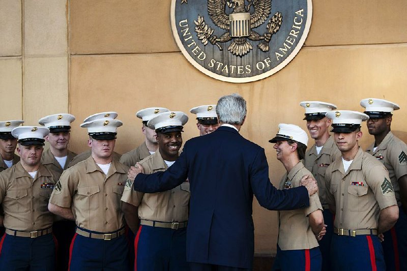 U.S. Secretary of State John Kerry greets U.S. Marines as he arrives at the U.S. Embassy in Baghdad, Iraq, Monday, June 23, 2014. Kerry said the fate of Iraq may be decided over the next week and is largely dependent on whether its leaders meet a deadline for starting to build a new government. (AP Photo/Brendan Smialowski, Pool)