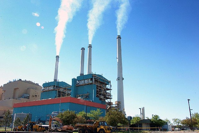 FILE - This July 1, 2013 file photo smoke rises from the Colstrip Steam Electric Station, a coal burning power plant in in Colstrip, Mont.  The Supreme Court on Monday placed limits on the sole Obama administration program already in place to deal with power plant and factory emissions of gases blamed for global warming. The justices said that the Environmental Protection Agency lacks authority in some cases to force companies to evaluate ways to reduce carbon dioxide emissions. This rule applies when a company needs a permit to expand facilities or build new ones that would increase overall pollution. Carbon dioxide is the chief gas linked to global warming. (AP Photo/Matthew Brown, File)