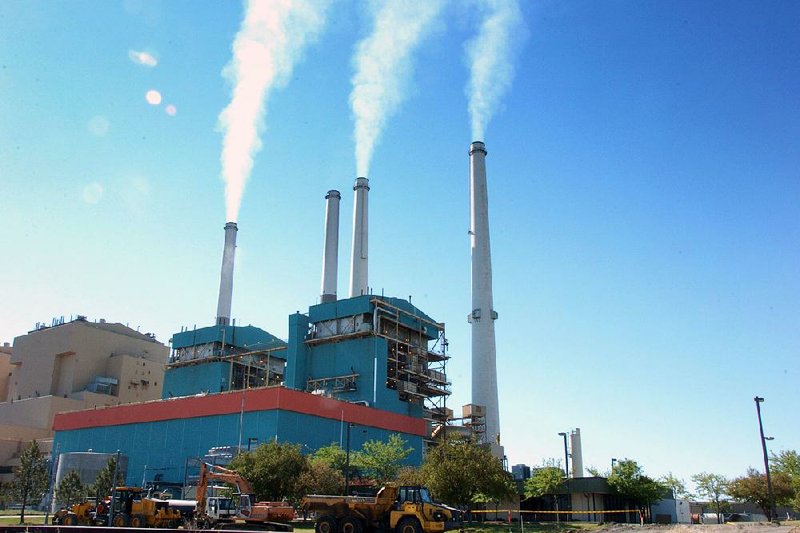 FILE - This July 1, 2013 file photo smoke rises from the Colstrip Steam Electric Station, a coal burning power plant in in Colstrip, Mont.  The Supreme Court on Monday placed limits on the sole Obama administration program already in place to deal with power plant and factory emissions of gases blamed for global warming. The justices said that the Environmental Protection Agency lacks authority in some cases to force companies to evaluate ways to reduce carbon dioxide emissions. This rule applies when a company needs a permit to expand facilities or build new ones that would increase overall pollution. Carbon dioxide is the chief gas linked to global warming. (AP Photo/Matthew Brown, File)