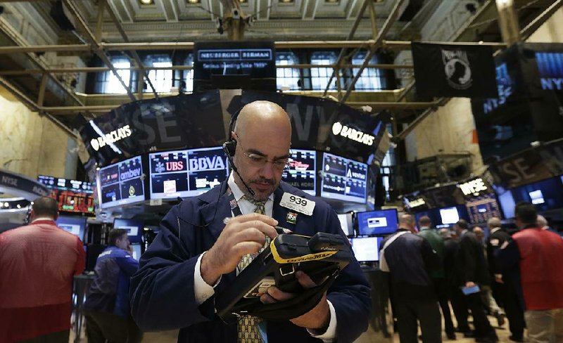 Trader Luigi Muccitelli works on the floor of the New York Stock Exchange Monday, June 23, 2014. Stocks are edging lower in early trading after indexed closed last week at record highs. (AP Photo/Richard Drew)