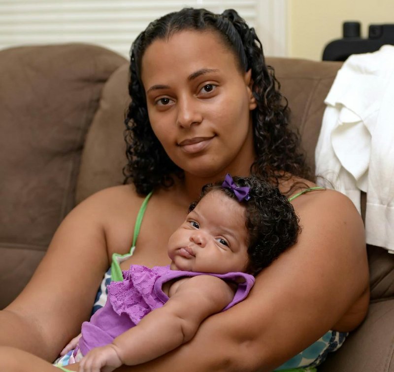 In this June 18, 2014 photo, Army Sgt. LaQuisha Gallmon holds her 2-month-old Abbagayle Gallmon while at her home in Greenville, S.C. Gallmon said that her local VA office had authorized her to see a private physician during her pregnancy, so she went to an emergency room after experiencing complications in her sixth month of pregnancy. She said the VA has thus far refused to pay the resulting $700 bill. (AP Photo/ Richard Shiro)
