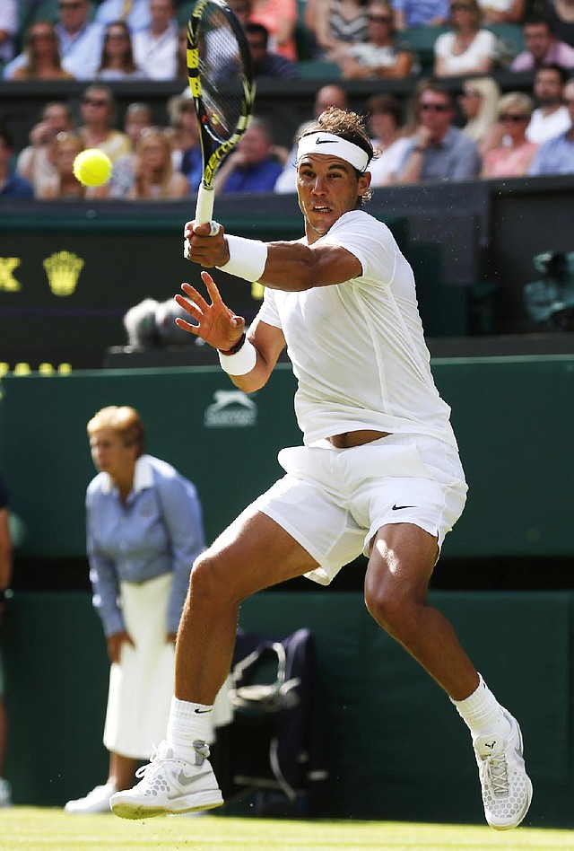 Second-seeded Rafael Nadal of Spain returns a shot to Martin Klizan of Slovakia on Tuesday during Nadal’s 4-6, 6-3, 6-3, 6-3 victory in his first match at Wimbledon this year.