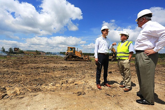 Michael Barelli (from left), vice president of New England Development, talks Tuesday with Lloyd Garrison, chief executive of CDI Contractors, the project manager, and Gus Vratsinas of Bailey Construction and Consulting, which is the on-site representative for New England Development at the site of the 176.4-acre Gateway Town Center development in southwest Little Rock.