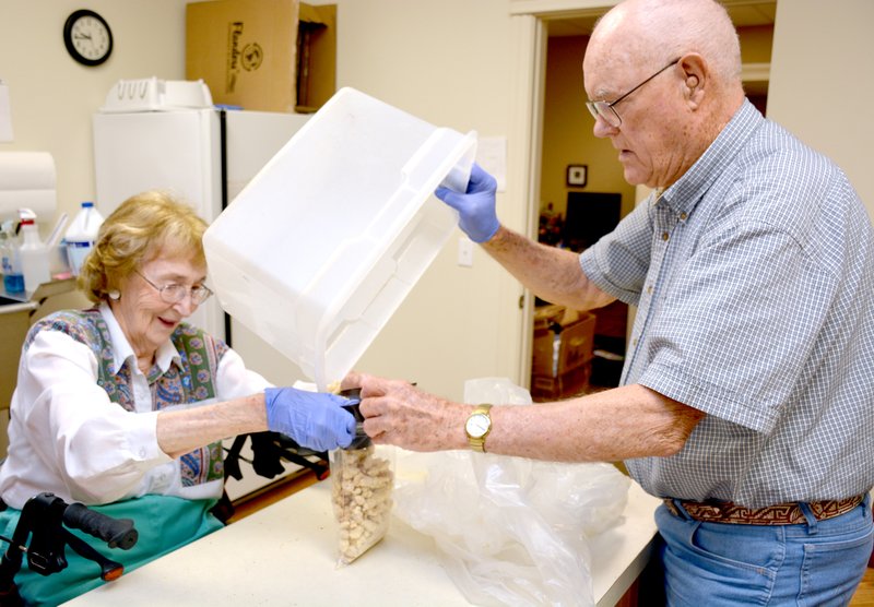 Jeff Della Rosa/Herald-Leader Leila and Paul McVay work together to put chicken into bags. The couple has been volunteering at the Manna Center since it was established in downtown more than 20 years ago.