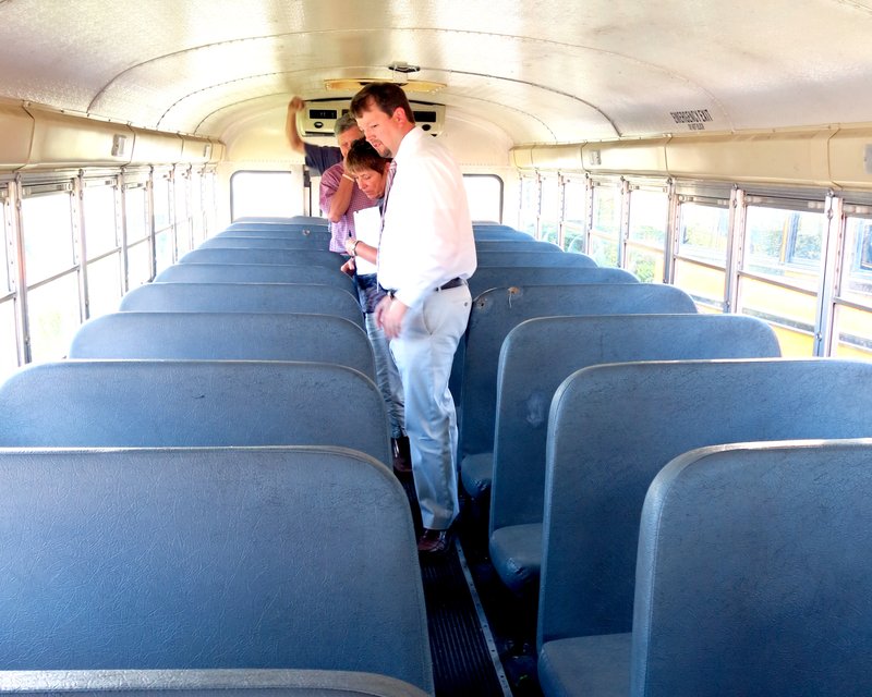 Photo by Mike Eckels Northside Elementary principal Jeff Gravette and school board vice-president Darleen Holly tour the inside of one of Decatur&#8217;s buses June 16. The board is considering purchasing a new activity bus.