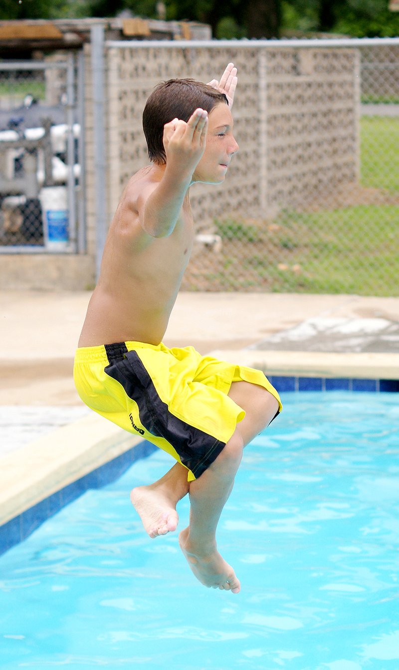 Photo by Randy Moll Cristopher Liske, 10, goes off the diving board at the Gravette Municipal Pool on Thursday. The pool is open 12 to 6 p.m. Monday through Saturday and 1 to 5 p.m. on Sunday.