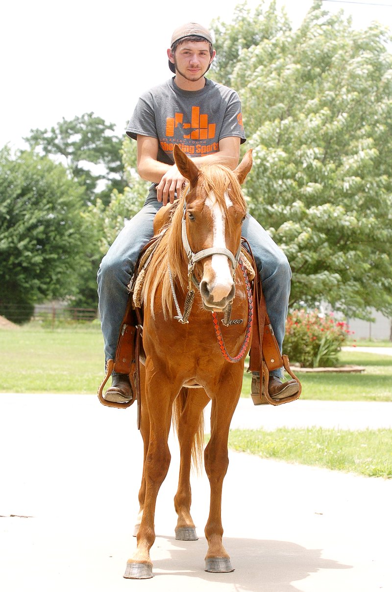 Photo by Randy Moll Tyler Woodall, riding Pistol, stopped along Pioneer Lane on June 18. Tyler was getting his horse accustomed to being around traffic on the roadway.