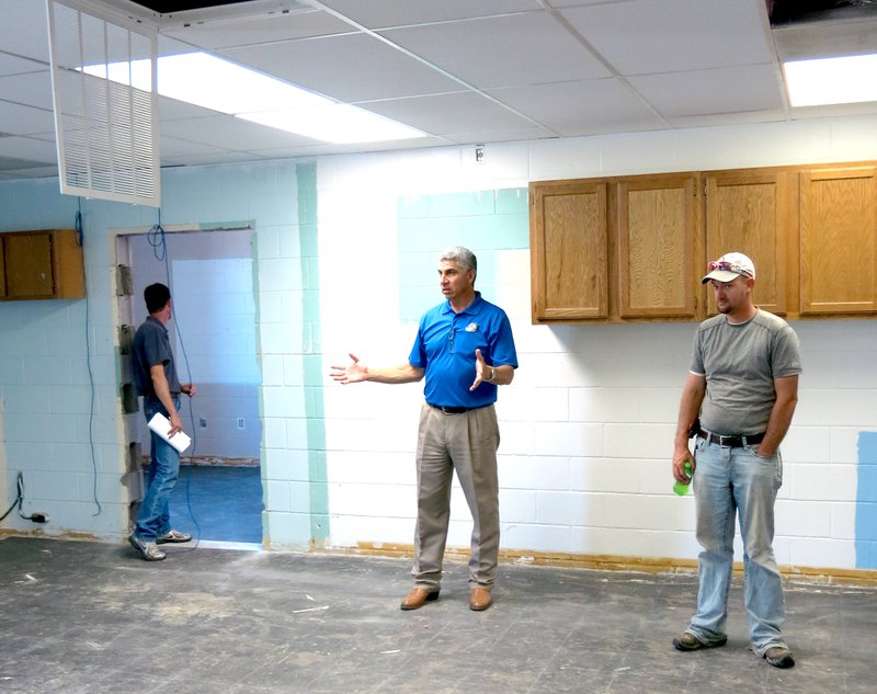 Photo by Mike Eckels Larry Ben (center), shows school board members Kevin Smith (right) and Aaron Owens (left) one of the sixth-grade classrooms under restoration at Decatur Middle School June 16. The facility is scheduled to open Aug. 18.