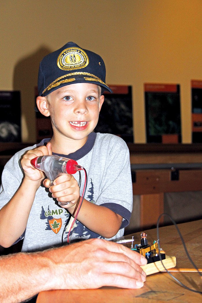 Dorian Dillion-Lee, 6, of Evansville, Ind., uses a hand-crank generator to make a light bulb glow during a visit to the Mid-America Science Museum in Hot Springs. When the museum is closed later this year for renovations, educational specialists from the museum will take science classes to nine schools in southern Arkansas. The instructors will also provide materials for teachers to have their own interactive science classes.