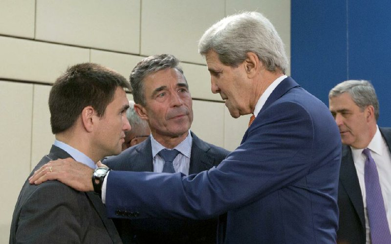 Ukrainian Foreign Minister Pavlo Klimkin (left) and NATO Secretary-General Anders Fogh Rasmussen (center) talk with U.S. Secretary of State John Kerry at a meeting Wednesday of NATO ministers in Brussels, where Russia was warned it could face further sanctions over the Ukraine crisis.