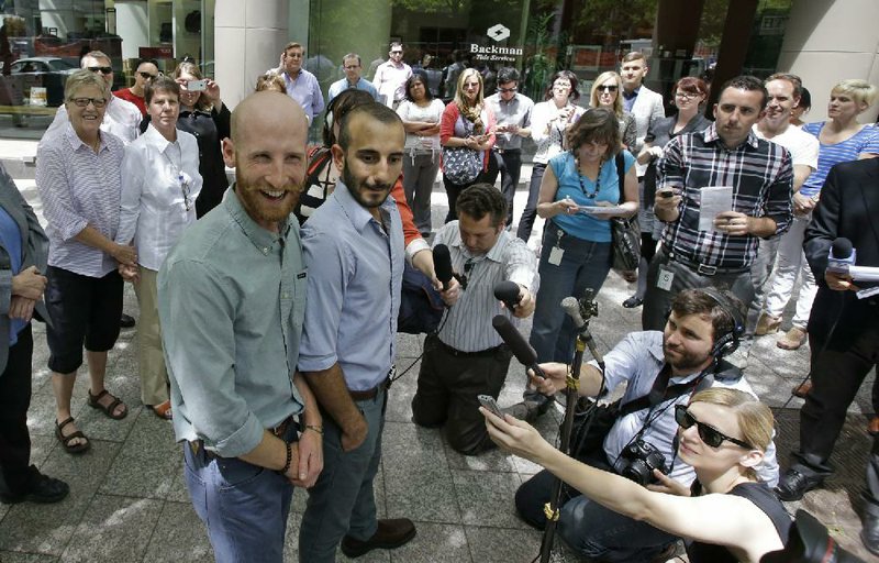 Derek Kitchen (left) and his partner, Moudi Sbeity, appear at a news conference Wednesday in Salt Lake City after a federal appeals court ruling allowing same-sex marriage in Utah and the five other states covered in the 10 U.S. Circuit Court of Appeals. However, the court stayed the ruling pending an appeal. 