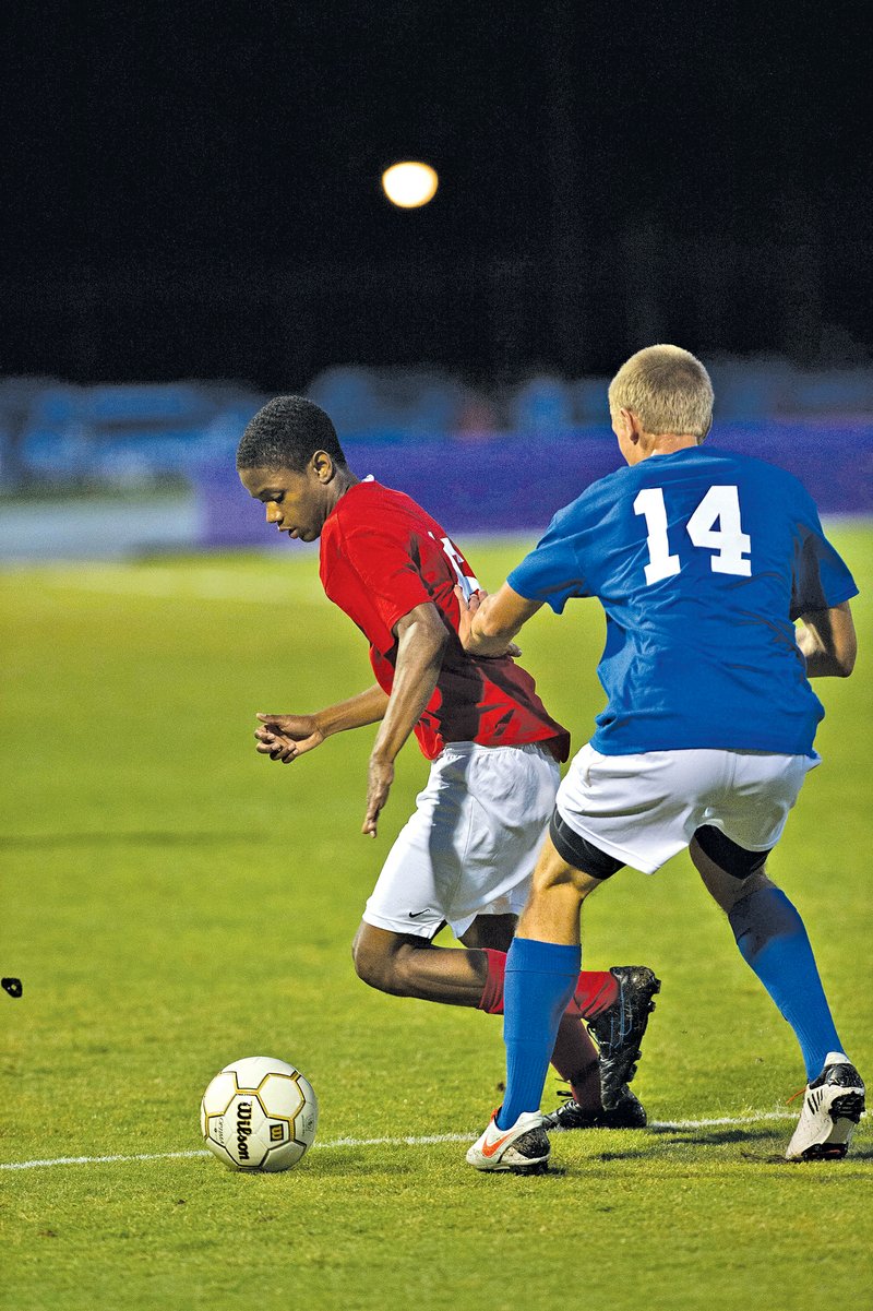 Special To NWA Media Todd Owens Tolliver Davis of Bentonville tries to get around an East defender Wednesday during the Arkansas High Schools Coaches&#8217; Association boys soccer All-Star game in Conway.