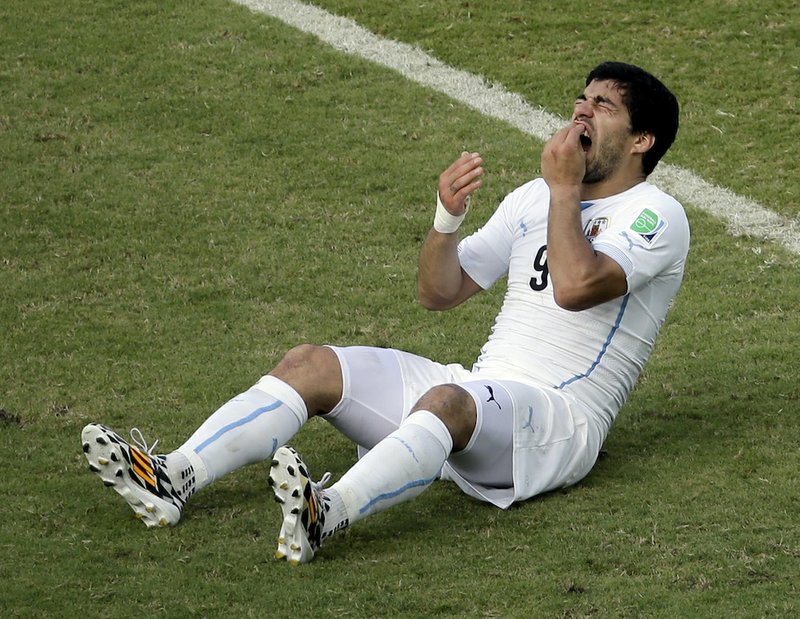 In this June 24, 2014, file photo, Uruguay's Luis Suarez reacts on the pitch during the group D World Cup soccer match between Italy and Uruguay at the Arena das Dunas in Natal, Brazil. On Thursday, June 26, 2014, FIFA banned Suarez for 9 games and 4 months for biting his opponent at the World Cup. 