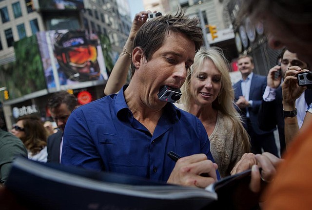 Nick Woodman, founder and chief executive officer of GoPro Inc., signs an autograph after ringing the opening bell for the release of the company's IPO at the Nasdaq MarketSite in New York, U.S., on Thursday, June 26, 2014. GoPro Inc., whose cameras let surfers, skiers and sky divers record their exploits, rose in its trading debut after pricing its initial public offering at the top of the marketed range. Photographer: Victor J. Blue/Bloomberg *** Local Caption *** Nick Woodman