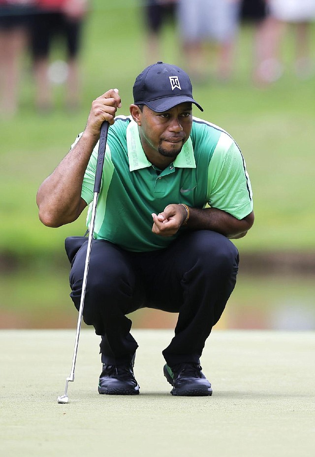 Tiger Woods lines up his putt on the sixth green during the first round of the Quicken Loans National on Thursday at Congressional Country Club in Bethesda, Md. Woods finished with a 4-over-par 74 in his first tournament since having back surgery.