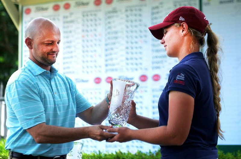 Chloe Horton (right) of Miami receives her trophy Thursday after winning the Stacy Lewis Open in Rogers. Horton defeated Clarie Cameron of Martinsville, Ind., by two strokes.