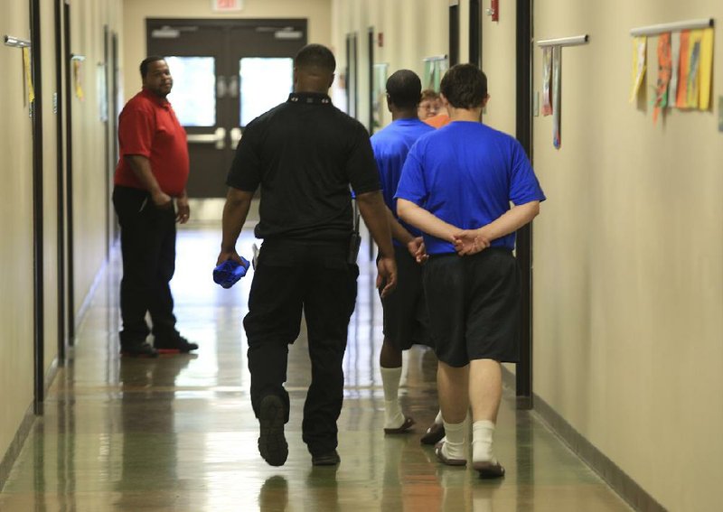 2014 FILE PHOTO: Staff members escort boys between classrooms at the Arkansas Juvenile Assessment and Treatment Center near Alexander. 