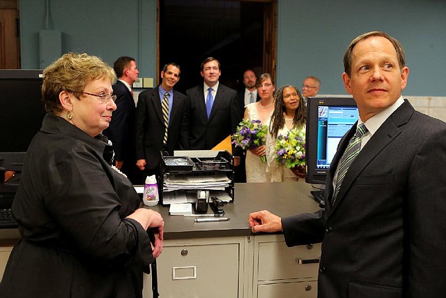 Recorder of Deeds Sharon Quigley Carpenter and St. Louis Mayor Francis Slay wait for marriage-license information to be entered into the computer after the weddings of four same-sex couples Wednesday at City Hall.