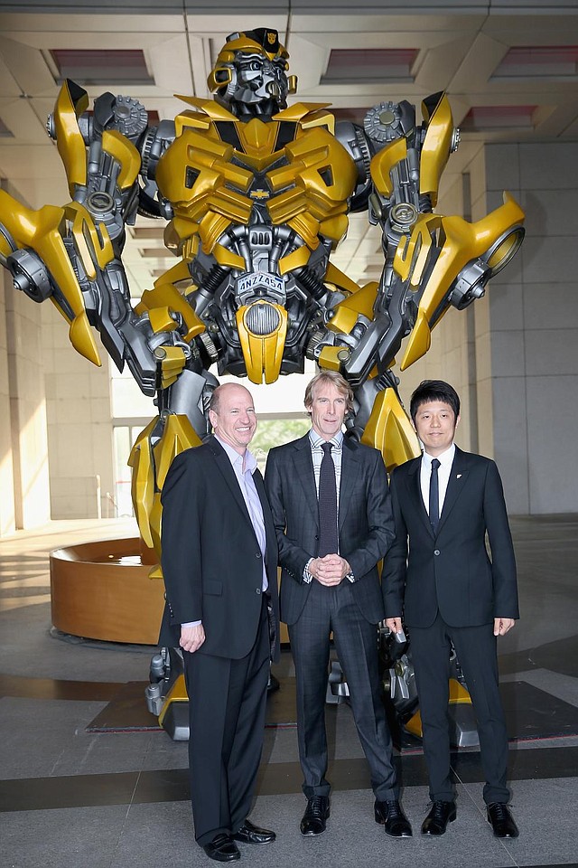 Vice Chairman of Paramount Rob Moore, director Michael Bay and Pangu Hotel general manager Norman Song pose for photos beside a Bumblebee Autobot at Beijing’s Pangu Hotel recently.