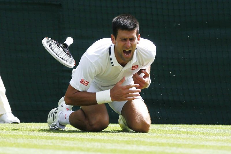 Novak Djokovic of Serbia shouts in pain after falling onto the court during the men's singles match against Gilles Simon of France at the All England Lawn Tennis Championships in Wimbledon, London, Friday, June 27, 2014. (AP Photo/Sang Tan)