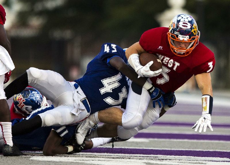 Arkansas Democrat-Gazette/MELISSA SUE GERRITS - 06/27/2014 -  West's Brandon Gates is taken down by East's Demarcus Rivers during the High School All Star football game June 27, 2014 at UCA in Conway. 