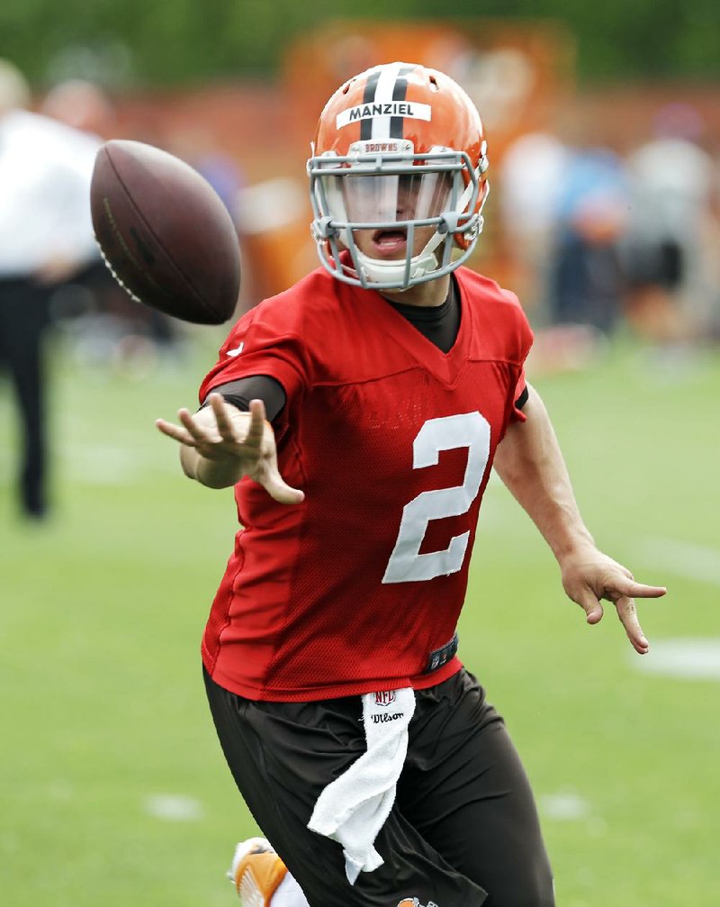 Cleveland Browns quarterback Johnny Manziel (2) pitches the ball at a mandatory minicamp practice at the NFL football team's facility in Berea, Ohio Wednesday, June 11, 2014. (AP Photo/Mark Duncan)